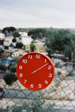 clock at 1:08 hangs from the chain-link fence, 35mm