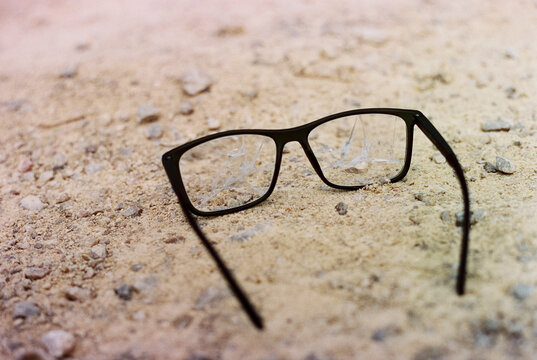 black glasses with broken lenses on the ground, 35mm