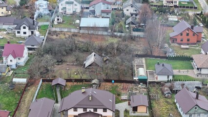 Cottage village in Eastern Europe. Dense cottage development. Abandoned plot in the middle of...