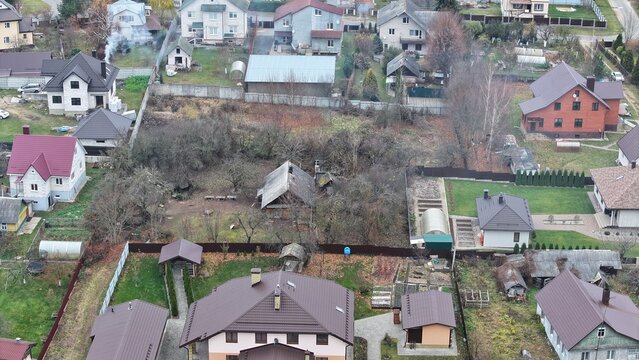 Cottage village in Eastern Europe. Dense cottage development. Abandoned plot in the middle of ennobled with rich expensive houses.
