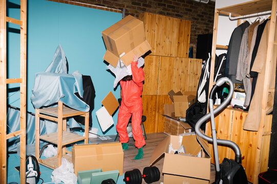 Person in Protective Suit Organizing Cluttered Storage Room