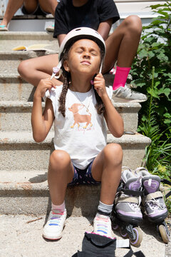Cute child putting on her helmet before going roller blading