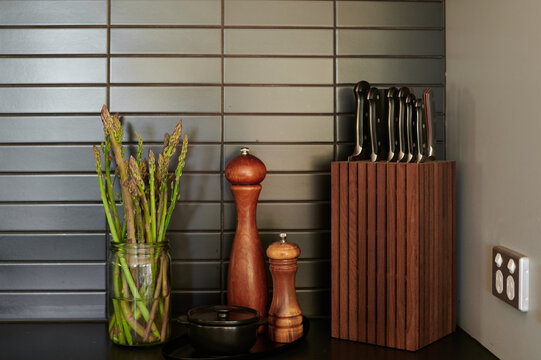 Stylish kitchen countertop with fresh asparagus and knife block
