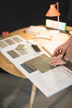 Hands reviewing fabric and material samples in design meeting