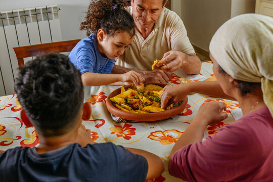 Multicultural family eating a moroccan dish Tajine