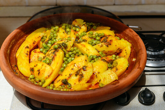 Opened Tajine with stew potatoes, chicken and peas