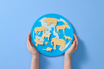 two hands holding with glob and animals. 