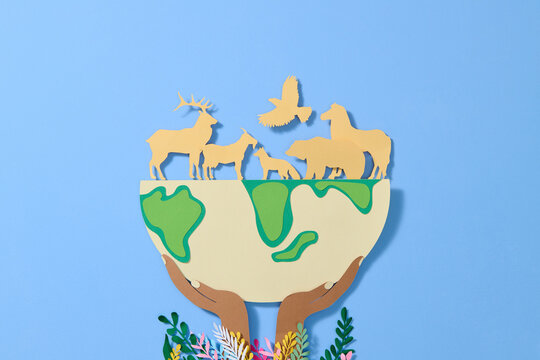 Group of wild animals and green nature with globe in hand.