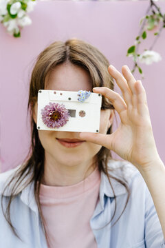 Woman holding cassette tape decorated with flowers