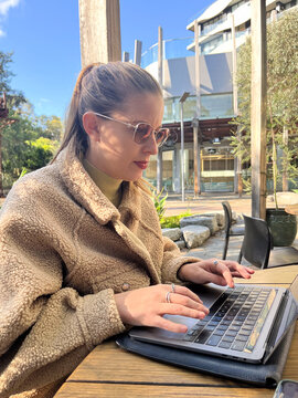 Woman working on laptop outdoors in a casual setting