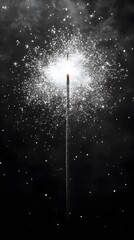 A sparkler emitting bright sparks against a dark background.