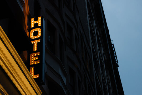 Glowing hotel sign on a building at night in New York City
