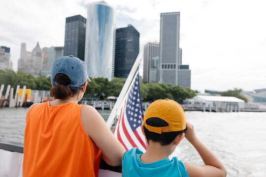 Exploring New York City by ferry with woman and child enjoying view.