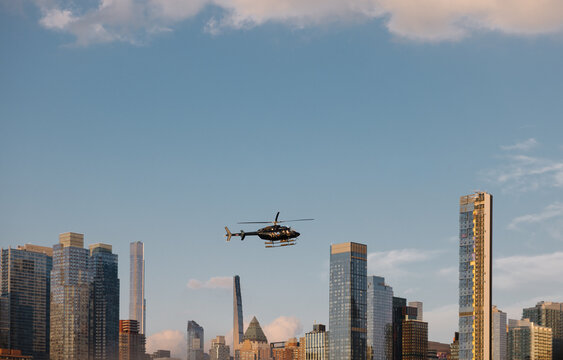 Helicopter flying over New York City skyline during sunset hour