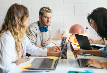 Office colleagues working in a coworking space with laptops