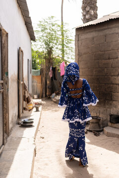Woman is walking away from the camera in a senegalese village