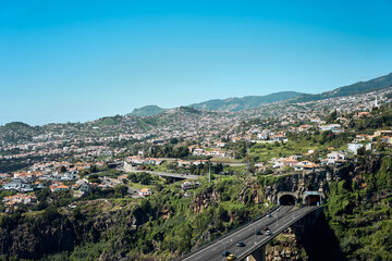 Scenic view of a mountainous landscape with highways and urban development in Madeira during daytime