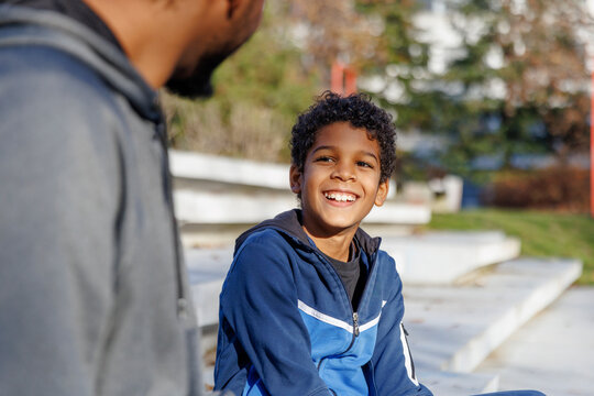 Happy son talking with father on steps
