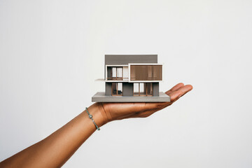 モダンな住宅模型を持つ手