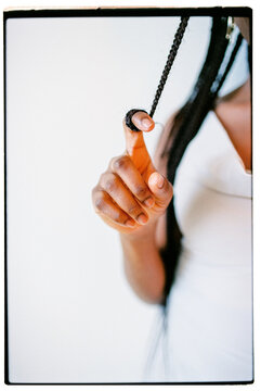 Cropped film closeup portrait of a hand holding a braid with a finger