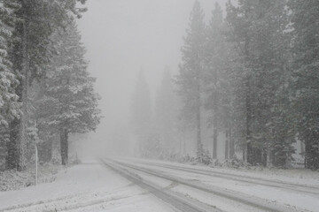 Snowy road in the Sierra Nevada mountains near Lake Tahoe.   Winter driving, heavy snow.