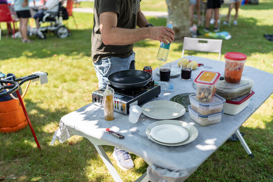 Man preparing lunch on camping stove during picnic with friends