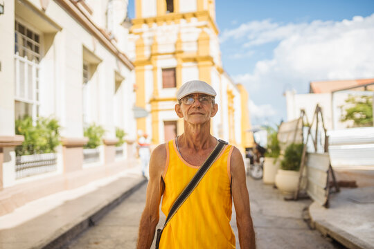 Man in yellow tank top on street