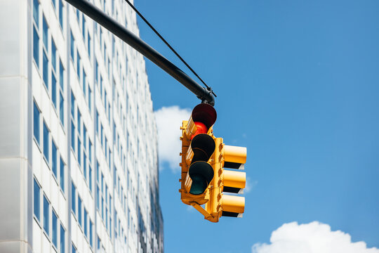 Traffic light against building and blue sky in New York