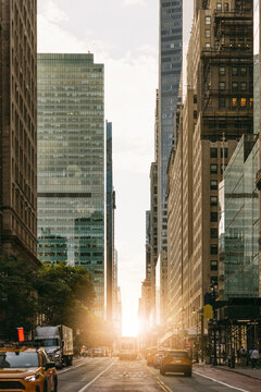 New York city street with skyscrapers and yellow taxis at sunset