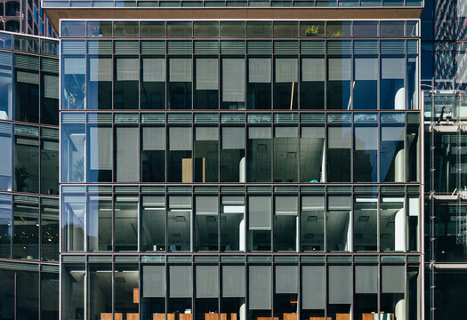 Modern glass office facade in New York with reflections and interior