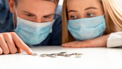 Coronacrisis concept. Young couple counting las money savings at home, close up