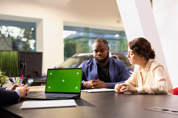 Salesperson using isolated screen notebook, applying sales tactic to persuade clients to make purchase. Sales executive using chroma key laptop encouraging customers to buy extra vehicle warranty