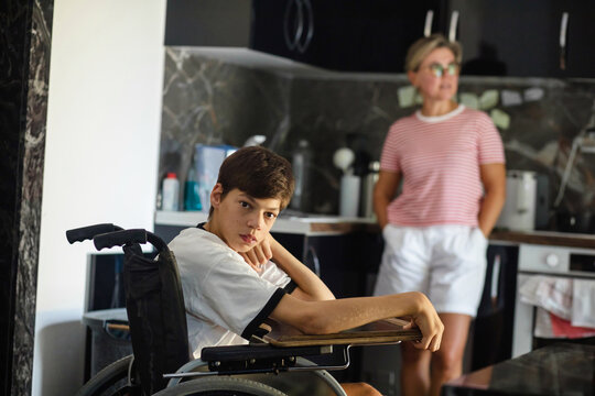 Disabled child and his mother in the kitchen