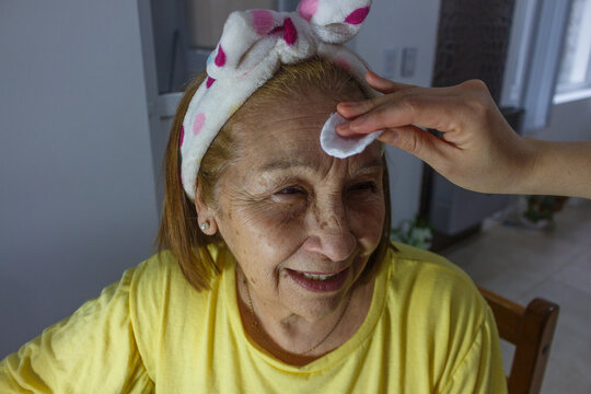 Elderly woman receiving a facial cleansing 