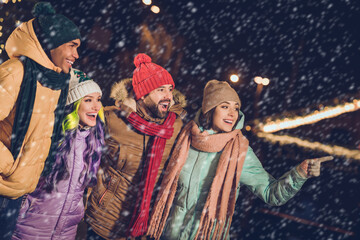 Naklejka premium Portrait of group funny excited buddies point finger look away far enjoy advent spirit season outside