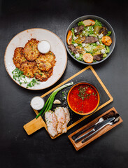 Ukrainian traditional meal spread with borscht, potato pancakes, salad, and smoked pork lard