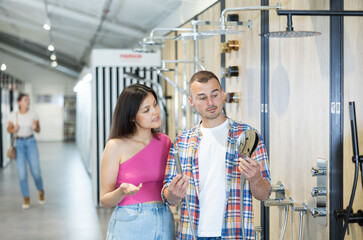 Married couple chooses a shower head in a hardware store