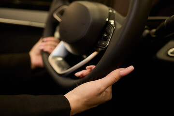 An up close image of a hand precisely adjusting a control in a luxurious automobile interior