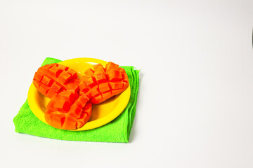 Mango slices on a yellow plate isolated on a white background