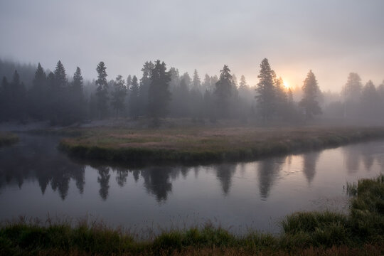 Sunrise over misty river