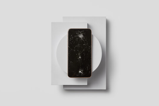 Top view on device with cracks on display on white surface