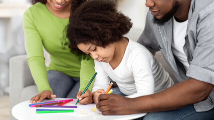 Caring African American Parents Teaching Their Little Daughter Drawing At Home, Enjoying Spending Time Together, Closeup