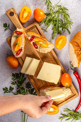 Chef preparing delicious bruschetta with cheese, tomatoes, rosemary, and chili peppers