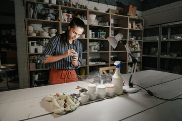Potter crafting delicate pieces in a serene studio at dusk