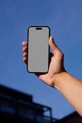 Hand-Held Smartphone Mockup with Clear Blue Sky Background