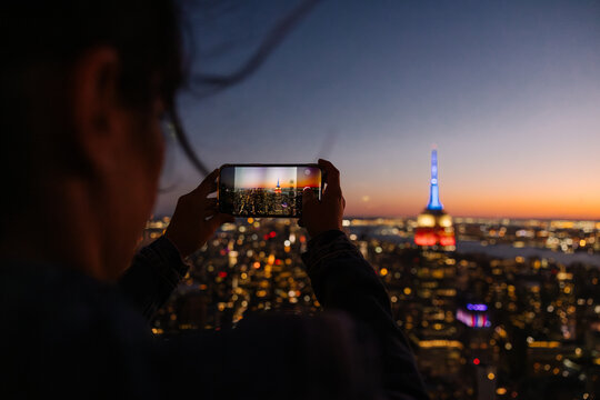 Evening cityscape view of NYC captured through a smartphone on rooftop