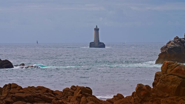 An ancient one standing far from the shore in the ocean and the first to meet huge waves Phare du Four a lighthouse in Bretagne France. 