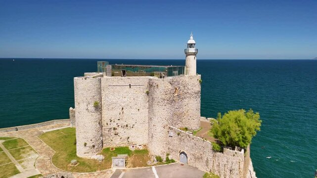 Drone landscape view of Santa Ana Castle-Lighthouse overlooking the blue sea on a sunny day