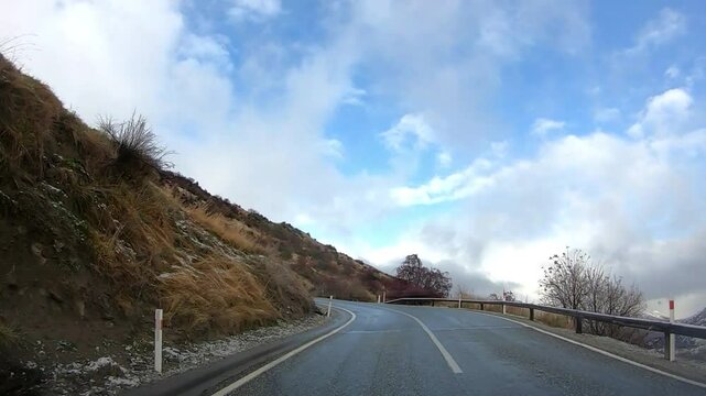 Scenic winter drive along Crown Range Road between Queenstown and Wanaka, Cardrona Oatgo New Zealand, Snow-covered mountains and winding roads serene alpine landscape