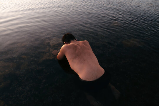 Shirtless muscular man in water